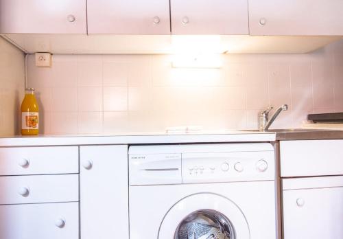 une cuisine avec une machine à laver et un évier dans l'établissement Perle du lac au coeur de la vieille ville, à Annecy