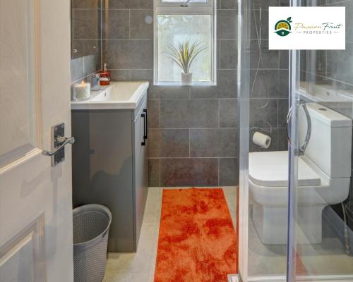 a bathroom with a toilet and a sink at 4 Bedroom House - Sleeps 7 Located Near Coventry Airport, City Centre, Free Unli Wi-fi - Driveway & Garden - AHC in Coventry