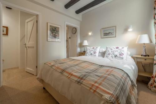 - une chambre dotée d'un grand lit avec des draps et des oreillers blancs dans l'établissement The Barn, à Burnham Market