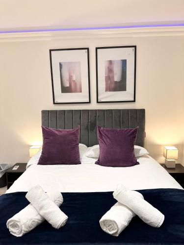 a bedroom with a bed with three towels on it at Stylish En Suite double room Kensington in London
