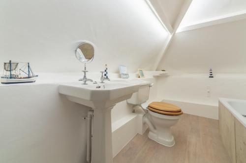 La salle de bains est pourvue d'un lavabo, de toilettes et d'une baignoire. dans l'établissement The Barn, à Burnham Market