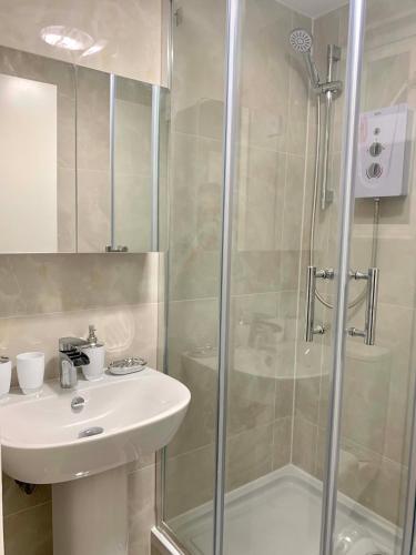 a bathroom with a sink and a shower at Stylish En Suite double room Kensington in London