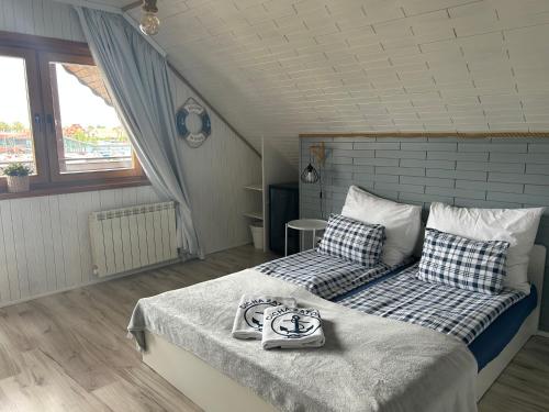 sypialnia z łóżkiem z niebiesko-białymi poduszkami w obiekcie Cicha Zatoka w mieście Mikołajki
