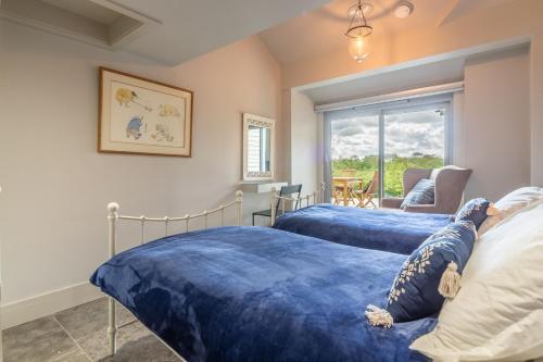 a bedroom with two beds with blue sheets at Peterstone Lodge in Holkham