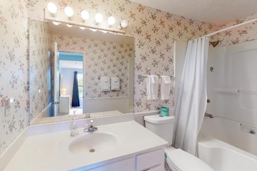 a bathroom with a sink and a toilet and a mirror at Gulf Highlands Grande Island Blvd in Panama City Beach