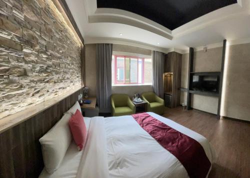 a hotel room with a bed and a stone wall at Alia Motel in Sanxia