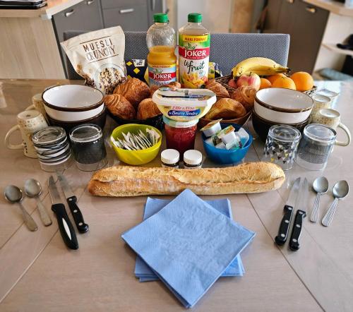einen Tisch mit einem Haufen Brot und anderen Lebensmitteln in der Unterkunft Circuit du Mans Jacques Brel in Guécélard