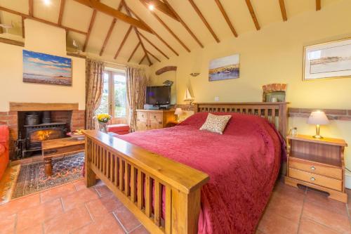 a bedroom with a large bed and a fireplace at Holland House Barn in Docking