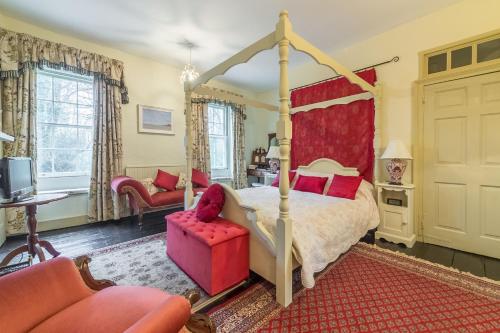um quarto com uma cama de dossel com detalhes em vermelho em Holland House 10 em Docking
