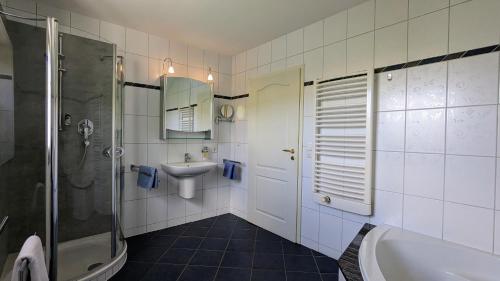 a bathroom with a shower and a sink and a tub at Haus an der Mosel in Bernkastel-Kues