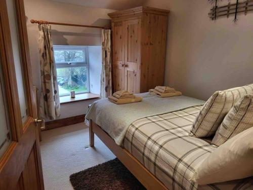 1 dormitorio con cama y ventana en Cosy cottage, Pateley Bridge, en Pateley Bridge