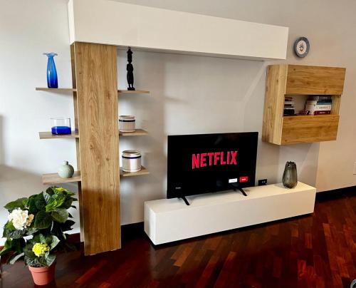 una sala de estar con TV en un estante blanco en INTERO APPARTAMENTO EUR Torrino NUOVO LiFeHome, en Roma