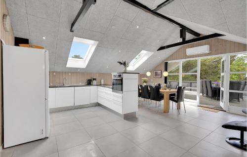 a kitchen and dining room with a table and chairs at Holiday Home Bjergbovej Blåvand Denm in Blåvand