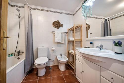 uma casa de banho com um WC, um lavatório e uma banheira em APARTAMENTO BONAVENTURA em Tavira