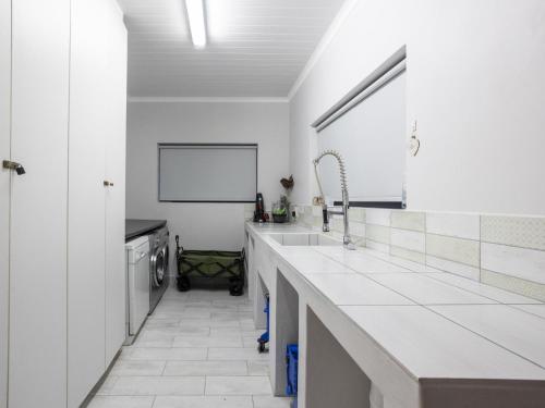 a white kitchen with a sink and a counter at The Gallery in Franskraal