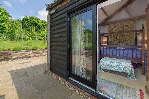 a sliding glass door on a house with a patio at Apple Tree Barn in Langham