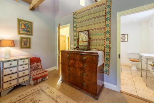 a bathroom with a sink and a wooden dresser at Apple Tree Barn in Langham