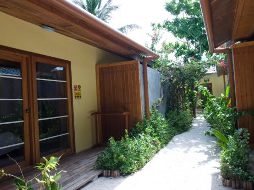 un porche de una casa con puerta de madera en RISING SUN BEACH VIEW, en Thinadhoo