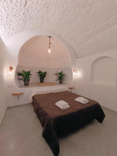 een slaapkamer met een bed met twee planten erop bij La Madriguera Eco Caves 3 in Guadix