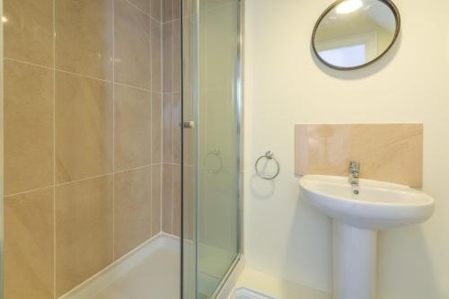 a bathroom with a shower and a sink and a mirror at Taureans in Wells next the Sea