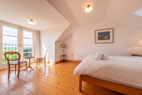 a bedroom with a bed and a table and chairs at Gallery Cottage in Wighton
