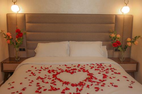 a bed with a heart made out of red roses at Hôtel Des Lilas in Oujda