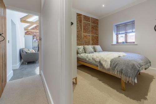 a bedroom with a bed and a brick wall at The Nurseries in Syderstone