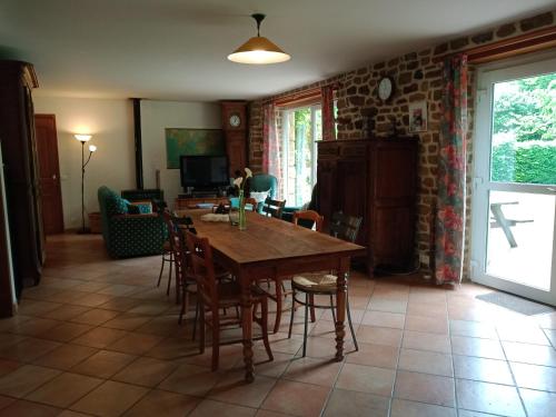un salon avec une table et des chaises en bois dans l'établissement GITE LE PRESSOIR DE LA BAIE 20 km DU MONT ST MICHEL, à Le Val-Saint-Père