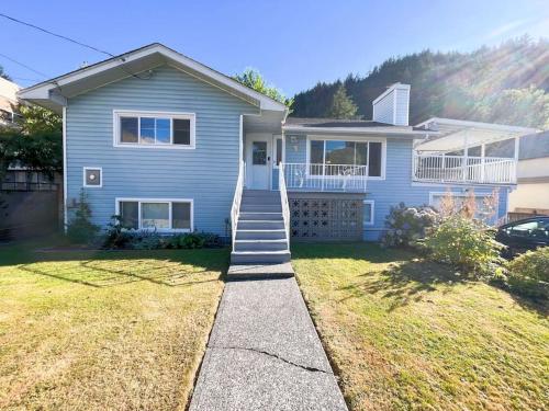 a blue house with stairs leading to the front door at Riverside Harrison Hotsprings House in Harrison Hot Springs