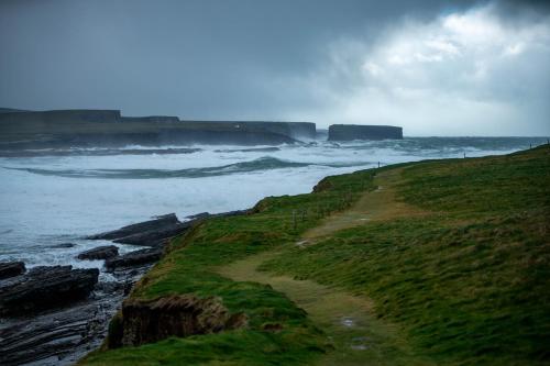 a path on a cliff next to the ocean at Móinéir House in Kilkee