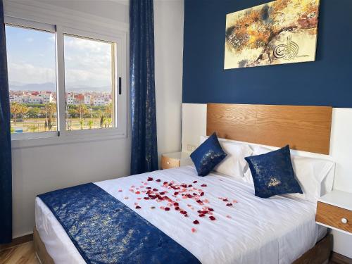 a bedroom with a bed with red roses on it at HOSTAL MH BORJ in Martil