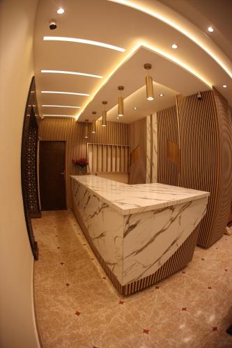 a large marble counter in a room with a mirror at Hôtel Des Lilas in Oujda