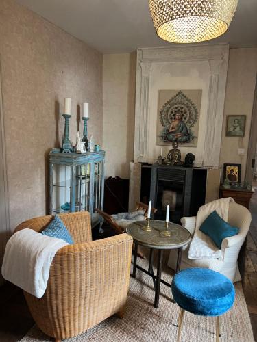 sala de estar con 2 sillas y mesa en Le Loriot, en Champagne-et-Fontaine