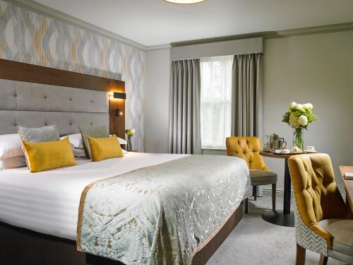 a hotel room with a large bed and a desk at Bridge House Hotel, Leisure Club & Spa in Tullamore