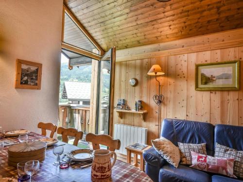 une salle à manger avec une table et un canapé dans l'établissement Duplex cosy T2 à proximité des pistes avec parking - 6 pers - La Turche, Les Gets - FR-1-685-6, aux Gets