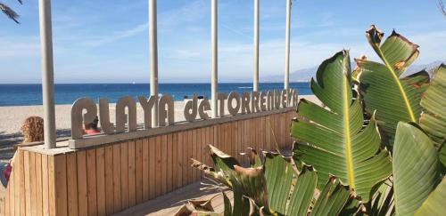 ein Schild an einem Strand mit dem Ozean im Hintergrund in der Unterkunft APARTAMENTO GRETA in Torrenueva