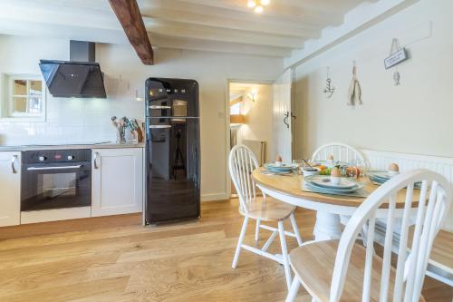a kitchen and dining room with a table and chairs at Swift Cottage in Dersingham