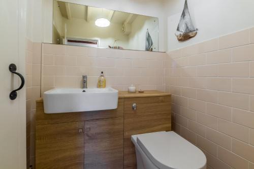 a bathroom with a sink and a toilet at Swift Cottage in Dersingham