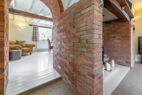 a brick wall in the middle of a living room at Swift Cottage in Dersingham
