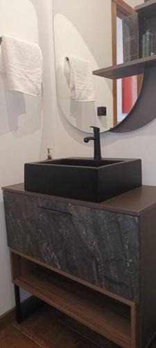 a bathroom with a black sink and a mirror at Piccolo Recanto in Bento Gonçalves