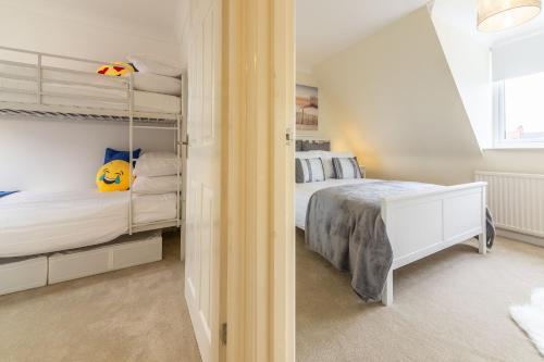 um quarto branco com uma cama e uma grande janela em Pebblesden em Hunstanton