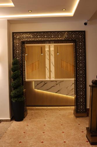 a lobby with a gold door with a plant at Hôtel Des Lilas in Oujda