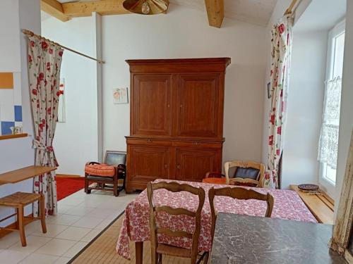 ein Esszimmer mit einem Tisch und Stühlen sowie einem Schrank in der Unterkunft La Maison du Marin in Saint-Gilles-Croix-de-Vie