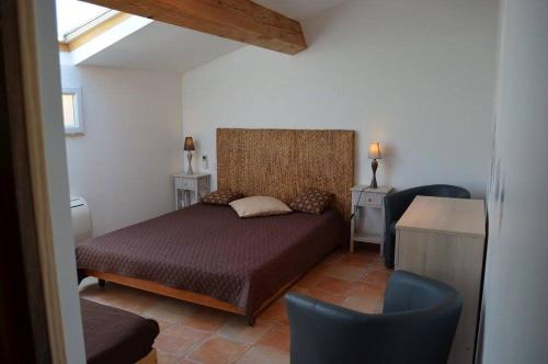 une chambre avec un lit, un bureau et des chaises dans l'établissement Au bon vivre, à Vivès