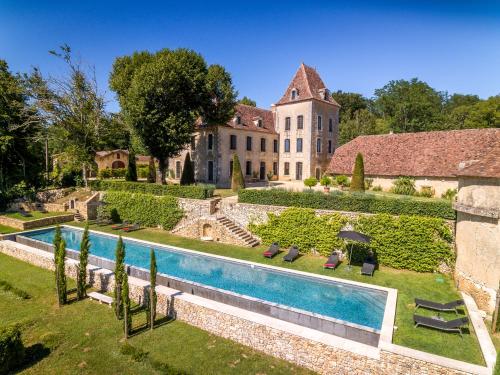 un domaine avec une piscine en face d'un bâtiment dans l'établissement Chateau de Lascoups, à Saint-Martin-des-Combes