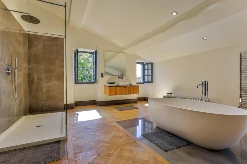uma grande casa de banho com uma grande banheira e um chuveiro em Chateau de Lascoups em Saint-Martin-des-Combes