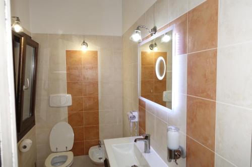 a bathroom with a sink and a toilet and a mirror at Little sea town apartment in La Ciaccia