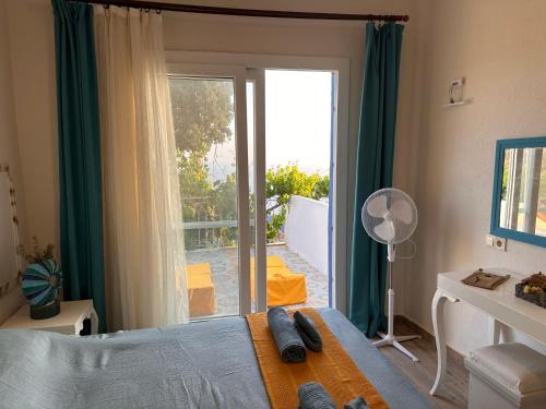 1 dormitorio con 1 cama y puerta corredera de cristal en Goknar Knidos Oasis Nature Hotel, en Datça