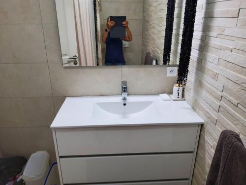 une femme prenant une photo d'un lavabo dans une salle de bains dans l'établissement Sanguinaires, à Ajaccio