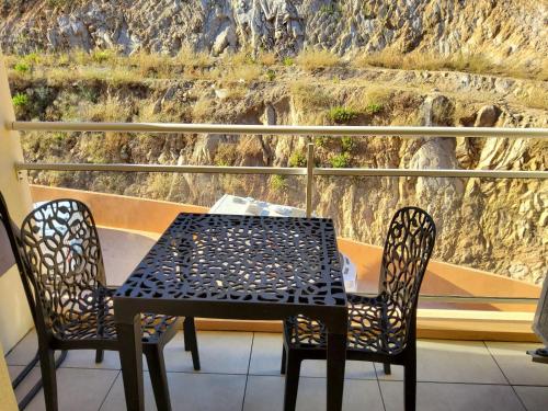 d'une table et de deux chaises sur un balcon avec vue. dans l'établissement Sanguinaires, à Ajaccio